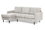 Een lichtbeige 3-zitsbank, model CL L+R in RIB920 naturel corduroy stof, met een chaise lounge aan de linkerkant en slanke zwarte metalen poten.
