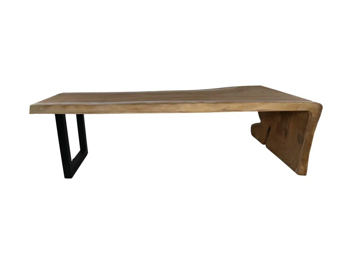 Een houten salontafel met een asymmetrisch, onregelmatig blad. Het heeft een natuurlijke houtafwerking en aan één kant zit een zwarte metalen poot die het ondersteunt. De andere kant heeft een houten verlengstuk dat een L-vormige basis vormt.