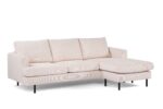 Een moderne beige sectionele bank met drie kussens en een chaise longue aan de rechterkant. Het heeft eenvoudige, rechte lijnen en zwarte metalen poten, tegen een witte achtergrond.