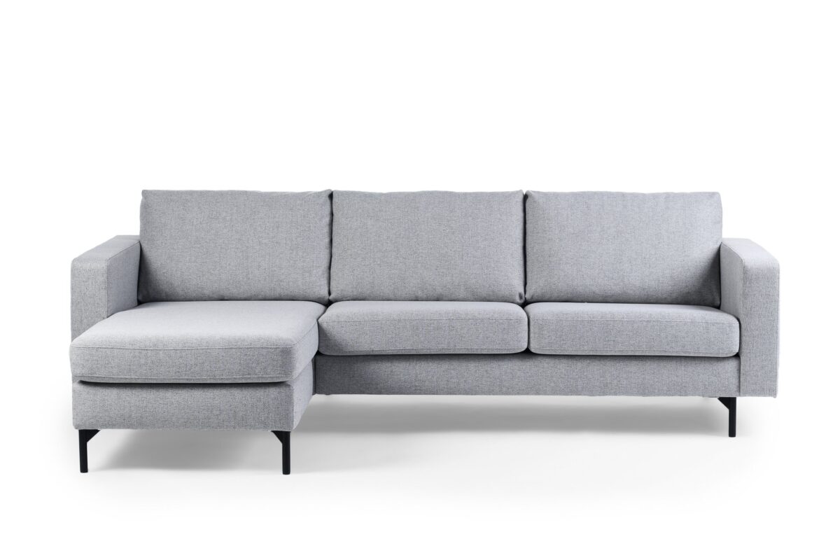 De 3 zits bank CL L+R in stoffen Chloe, kleur C311 grijs, is een moderne lichtgrijze sectionele bank met een linker chaise, drie zitkussens en zwarte metalen poten tegen een witte achtergrond.
