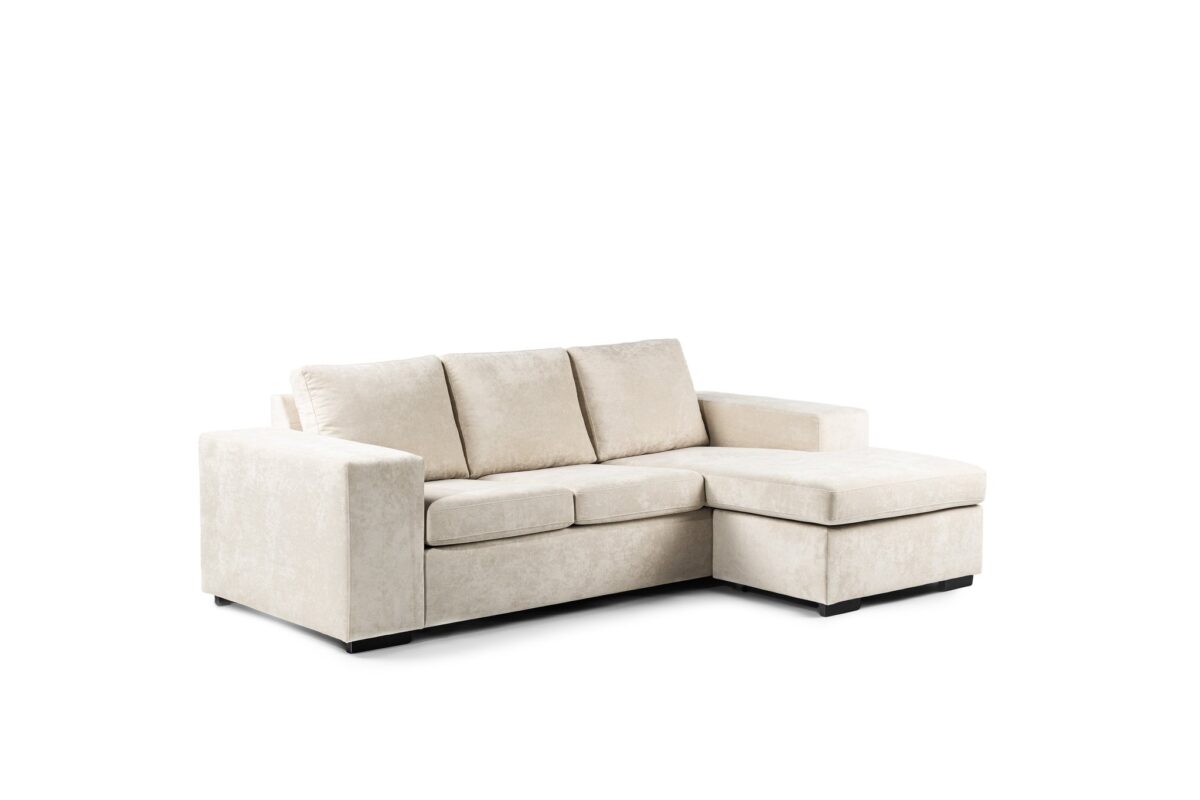 Beige hoekbank met drie kussens en een chaise longue aan de rechterkant, tegen een effen witte achtergrond.