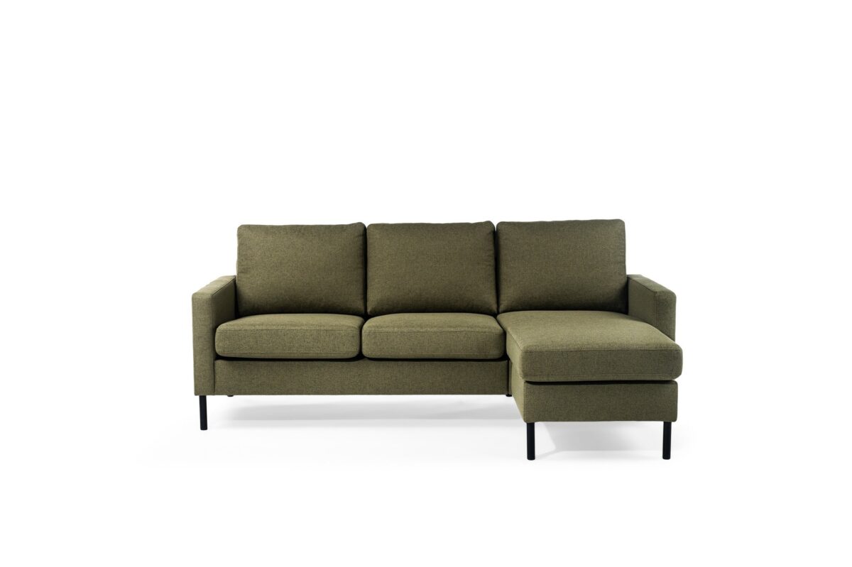De 3 zits bank CL L+R in Dillon D156 groene stof heeft drie zitkussens, een chaise aan de rechterkant, smalle armleuningen en zwarte poten, afgebeeld tegen een effen witte achtergrond.