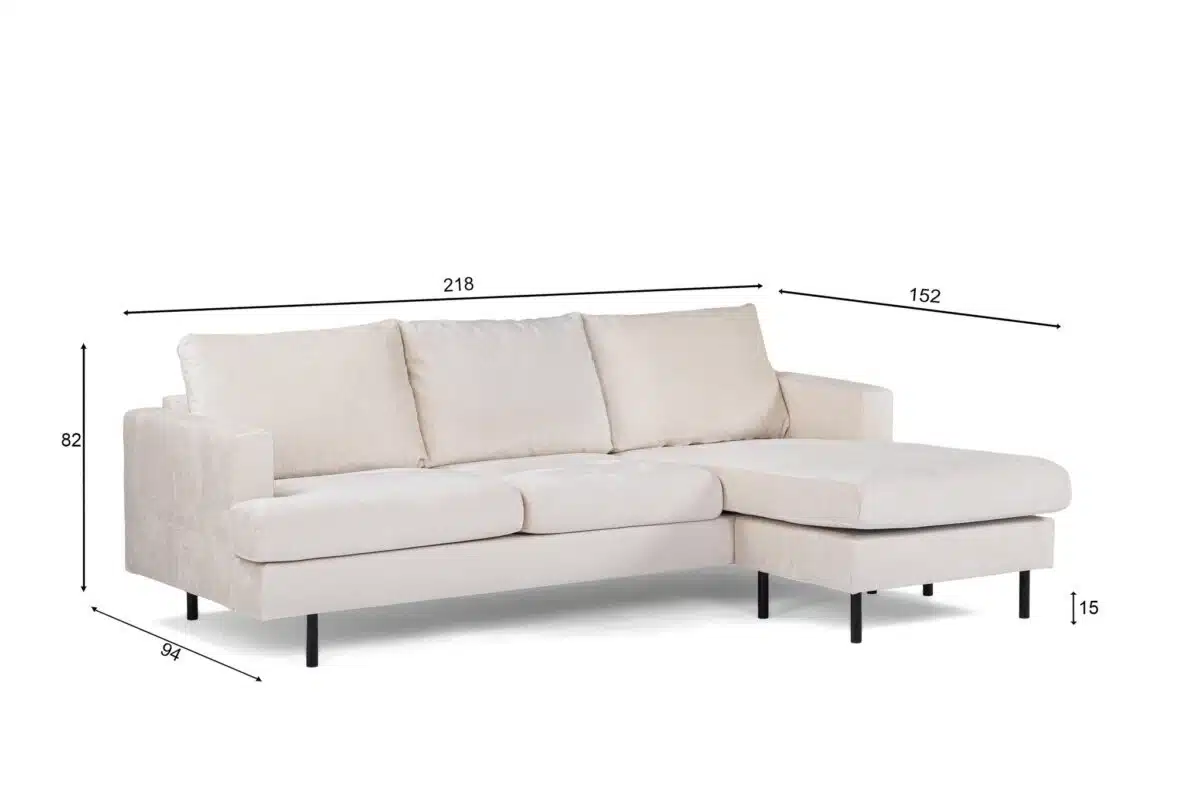 Een beige sectionele bank met zwarte poten op een witte achtergrond. De bank heeft drie kussens en een chaise longue aan de rechterkant. Afmetingen zijn weergegeven in de afbeelding: 218 cm breed, 84 cm diep, 82 cm hoog, 152 cm voor de chaise longue en 15 cm poothoogte.