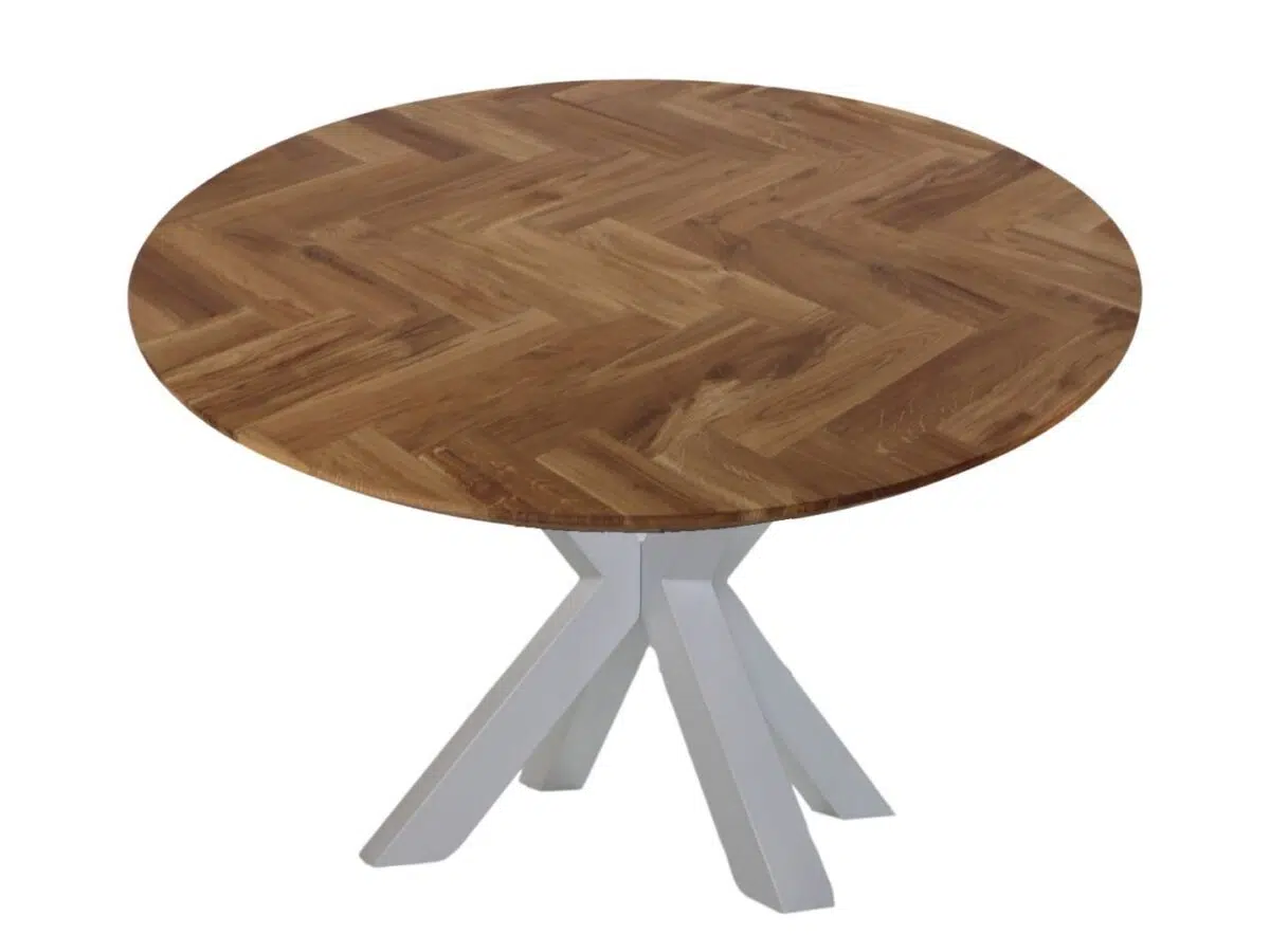 Een ronde houten tafel met een visgraatmotief op het blad. De tafel heeft een set van vier schuine witte poten die in het midden samenkomen en het tafelblad ondersteunen.