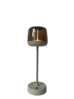 Een moderne tafellamp met een strakke, metalen koepelvormige kap op een cilindrische standaard en ronde voet. De lamp is verlicht en heeft een minimalistisch, eigentijds design.