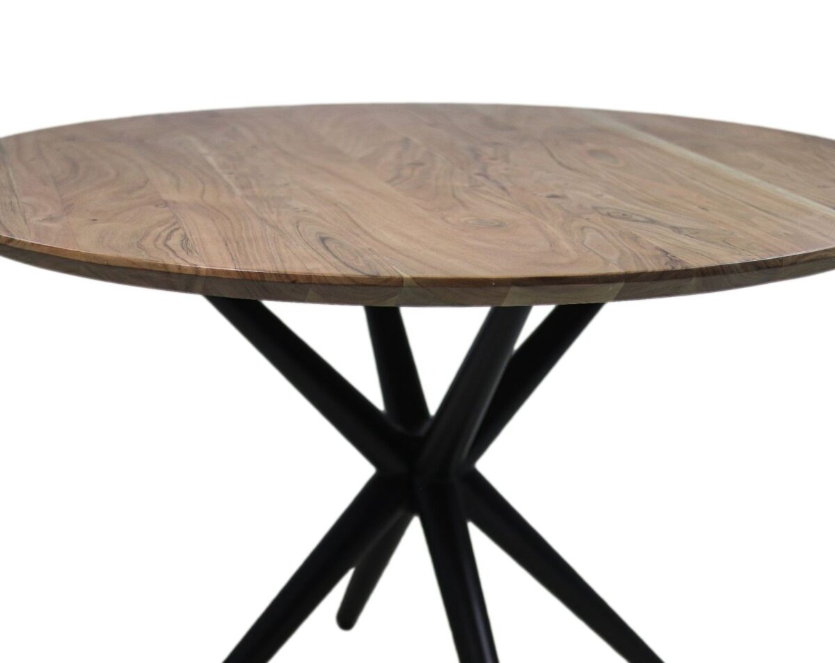 Een ronde houten tafel met een natuurlijke afwerking en een opvallende houtnerf. Het tafelblad wordt ondersteund door een unieke, moderne zwarte metalen driepoot-stijl basis die in het midden samenkomt.