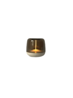 Een kleine, cilindervormige, moderne lamp met een doorschijnende bruine kap en een warm gloeiend licht van binnen, afgezet tegen een effen witte achtergrond.