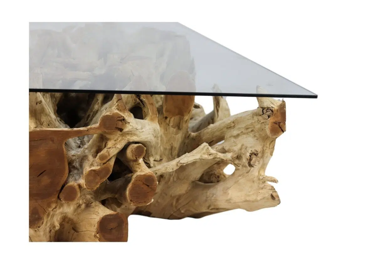 Een tafel met een glazen blad en een onderstel van zorgvuldig gerangschikte, natuurlijke stukken drijfhout, wat een rustiek en artistiek ontwerp oplevert.