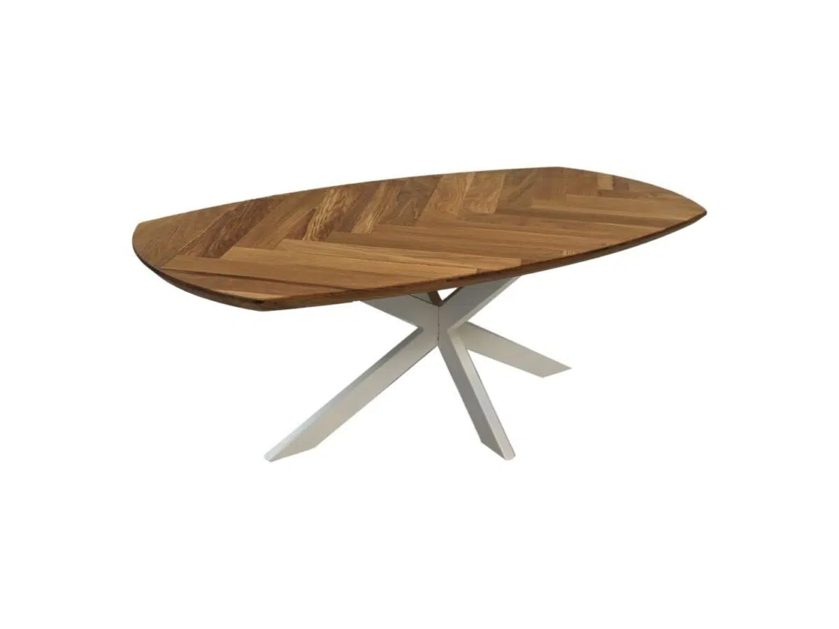 Een moderne houten eettafel met een ovaal blad met visgraatmotief. Het heeft een unieke witte metalen basis met hoekige, kruisende poten, die contrasteren met de warme houtafwerking. De achtergrond is effen wit.