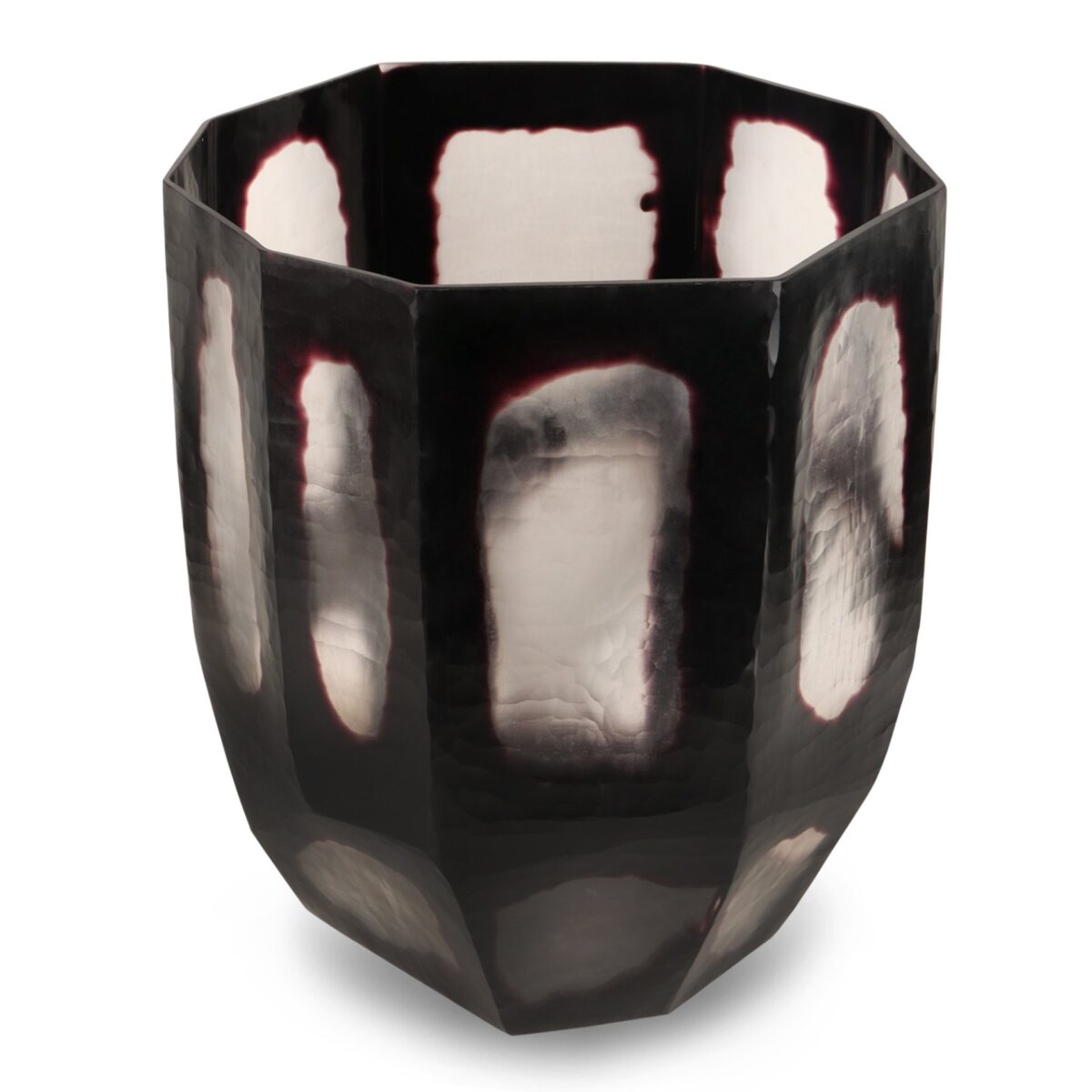 Een gefacetteerd, metalen beeldhouwwerk met een reflecterende, achthoekige vorm en een donker oppervlak met lichtere, ongelijke plekken. Het stuk heeft een modern, abstract ontwerp met gladde randen en een getextureerd uiterlijk.