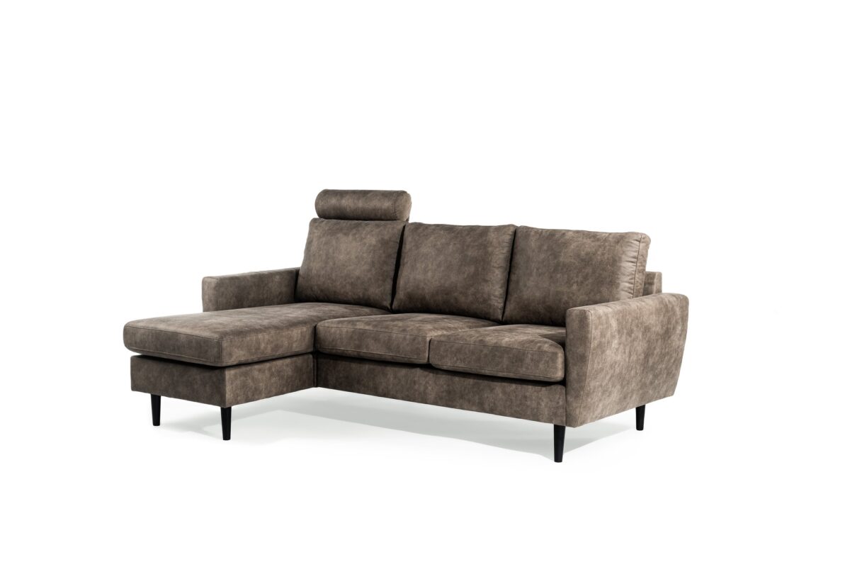 Een moderne bruine sectionele bank met een chaise longue aan de linkerkant, gestoffeerde zittingen en een hoofdsteun op de rugleuning. De bank heeft slanke zwarte poten en staat tegen een effen witte achtergrond.