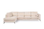 Een grote, lichtbeige sectionele bank met een chaise longue aan de linkerkant. De bank heeft een strak, modern design met slanke zwarte poten en wordt geleverd met een bijpassend rond sierkussen.