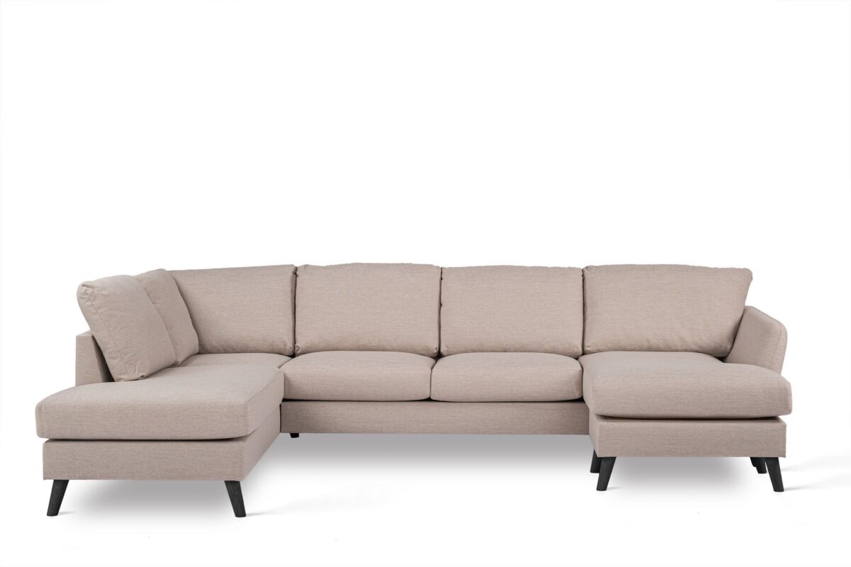 Een beige L-vormige sectionele bank met vijf gestoffeerde zittingen. De bank heeft zwarte poten en ziet er modern en comfortabel uit, tegen een effen witte achtergrond.