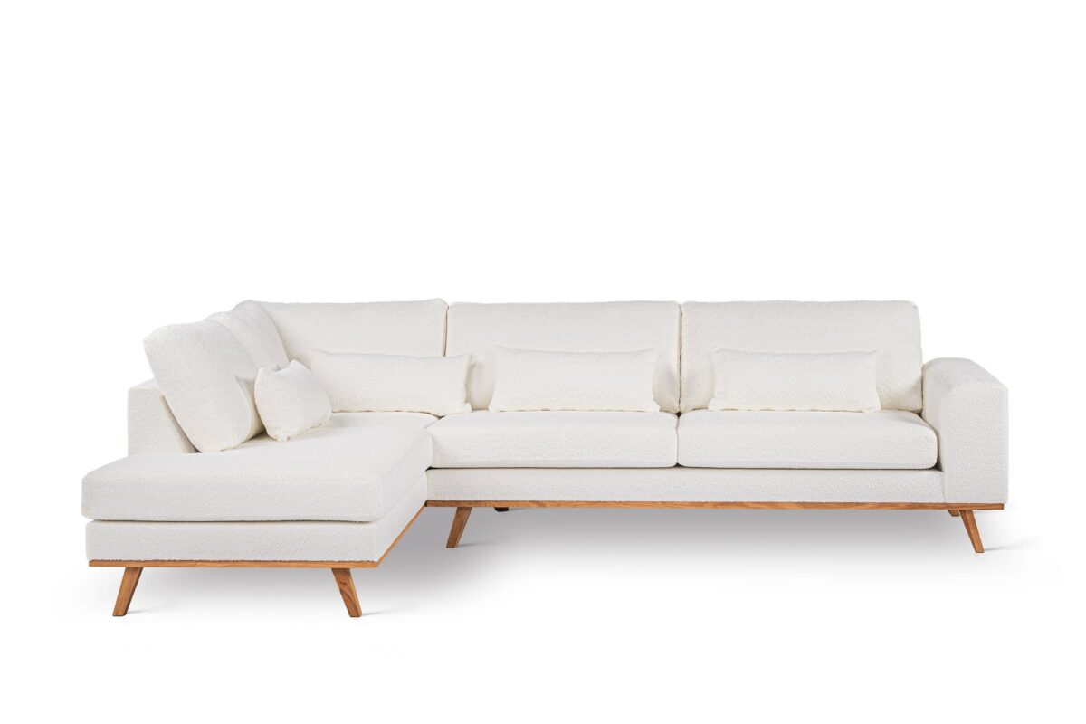 Een moderne, witte L-vormige bank met houten poten. De bank heeft een chaise longue aan de linkerkant en bevat verschillende bijpassende kussens. Het ontwerp is minimalistisch tegen een effen witte achtergrond.