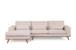 Een moderne beige sectionele bank met houten poten. De bank heeft drie zitkussens en een loungegedeelte aan de linkerkant, waardoor een ruime en comfortabele zithoek ontstaat.