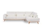 Een moderne witte sectionele bank met een houten basis en poten, met drie zitkussens, een chaise longue aan de rechterkant en vijf bijpassende witte rugkussens. De achtergrond is effen wit.