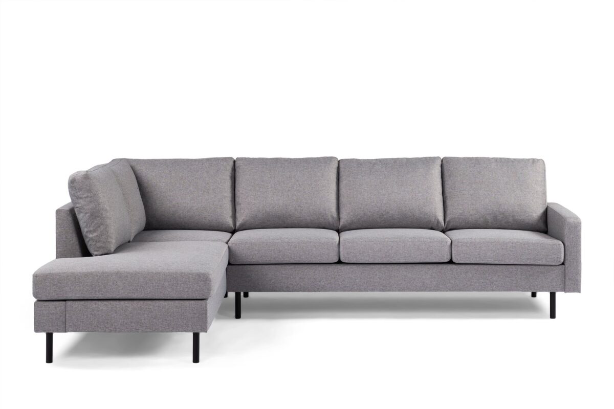 Een moderne, grijze sectionele bank met een chaise longue aan de linkerkant. Het heeft strakke lijnen, zachte kussens en wordt ondersteund door zwarte poten. De bank staat tegen een effen witte achtergrond.