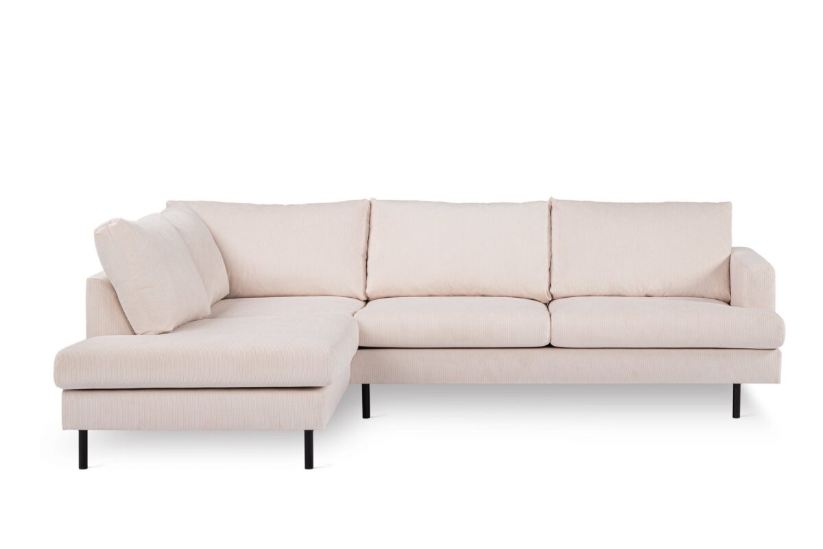 Een lichtbeige L-vormige sectionele bank met drie zitkussens en een chaise longue aan de linkerkant. De bank heeft zwarte metalen poten en staat op een effen witte achtergrond.