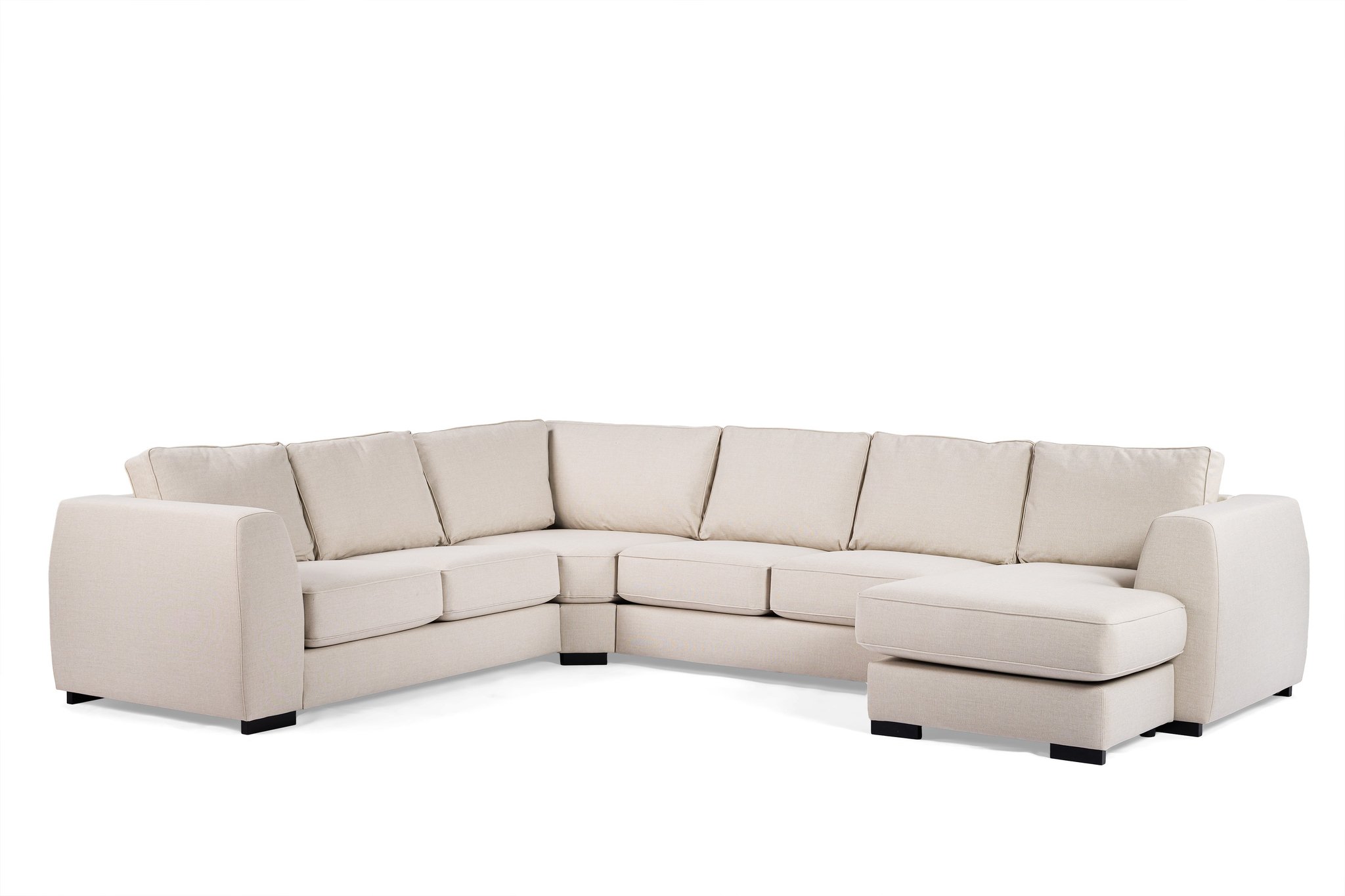 Beige L-vormige hoekbank met zachte kussens en een chaise longue aan de rechterkant, tegen een effen witte achtergrond.