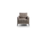 Een grijze, moderne fauteuil met vierkante armleuningen en een gewatteerde zitting, geplaatst tegen een witte achtergrond. De stoel heeft korte, zwarte poten.