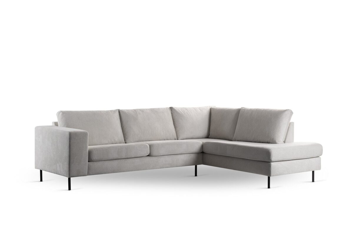 Een beige, naar rechts gericht L-vormig bankstel (3 zits hoek rechts) in stof Lord 22 met slanke zwarte poten, voorzien van drie zit- en rugkussens, afgebeeld tegen een witte achtergrond.