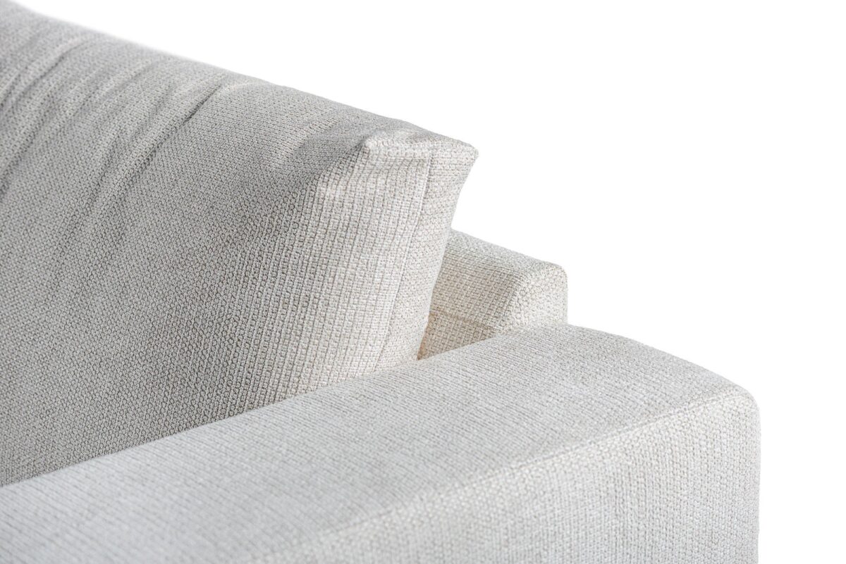 Close-up van de 3 zits hoek links sofa in E460 beige Lord 22 stof, met de gestructureerde bekleding, het rugkussen en de bovenste armleuninghoek tegen een witte achtergrond.