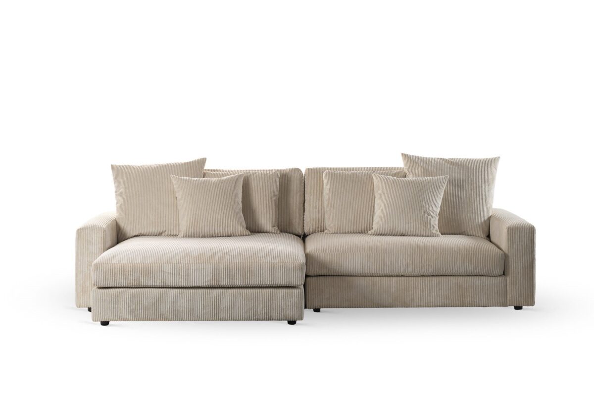De 3 zits bank CL L+R, bekleed met stof Lincoln 83 in RIB920 naturel, is een beige hoekbank met chaise lounge links, rechte armleuningen en zes bijpassende kussens, gefotografeerd tegen een witte achtergrond.