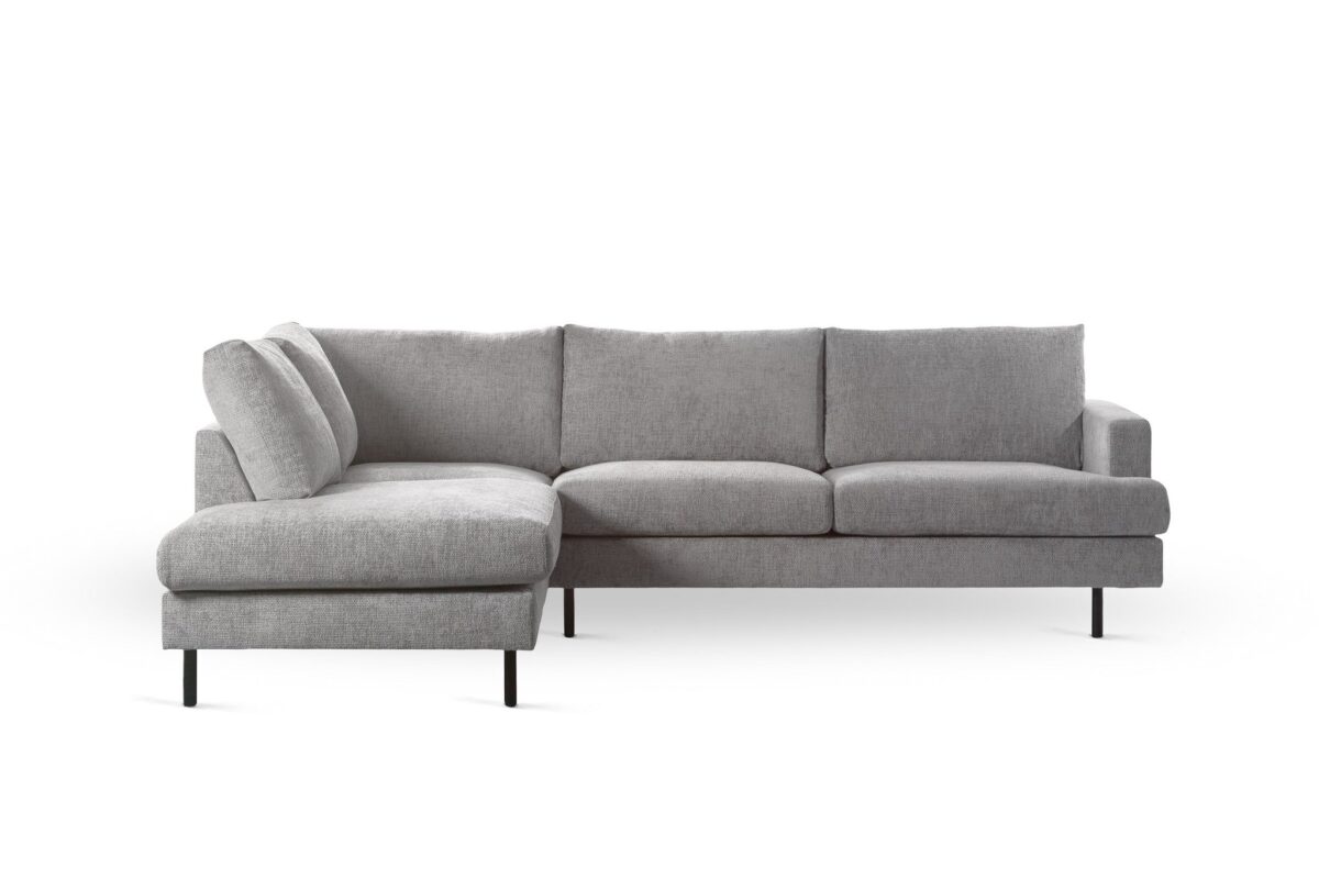 Een moderne 3-zits hoekbank in Haga 08 stof (E920 naturel), met een naar links gerichte chaise, drie zitkussens en slanke zwarte poten, tegen een effen witte achtergrond.