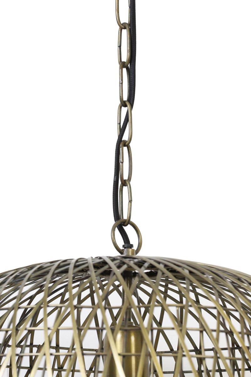 Close-up van een hangende hanglamp met een koepelvormig metalen draadkooiontwerp. De kooi is verbonden met een ketting en een zwart snoer, gedeeltelijk zichtbaar aan de bovenkant. Het metaal heeft een messing afwerking en de witte achtergrond benadrukt de ingewikkelde structuur.