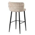 Een moderne barkruk met een beige, gewatteerde, stoffen rugleuning en zitting. Het heeft vier strakke zwarte poten met een aansluitende voetensteun. Het ontwerp is eigentijds en elegant, ideaal voor keuken- of barruimtes.