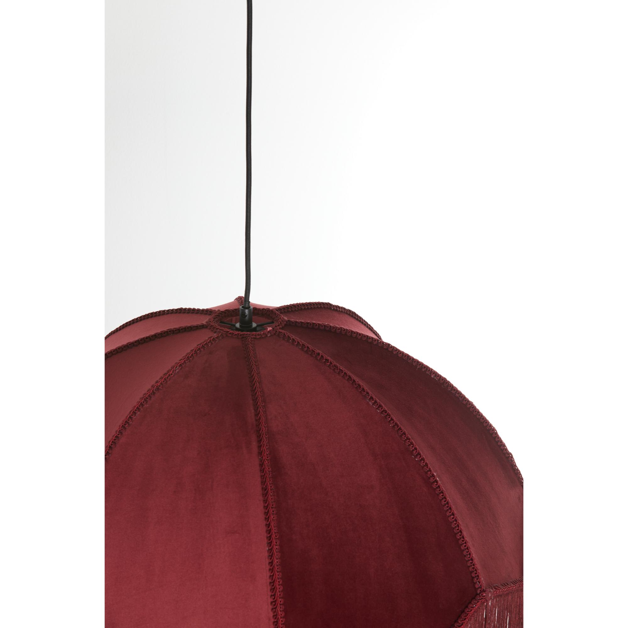 Een close-up van een rode, koepelvormige hanglamp met decoratieve naden en franjedetail, hangend aan een zwart snoer tegen een witte achtergrond.