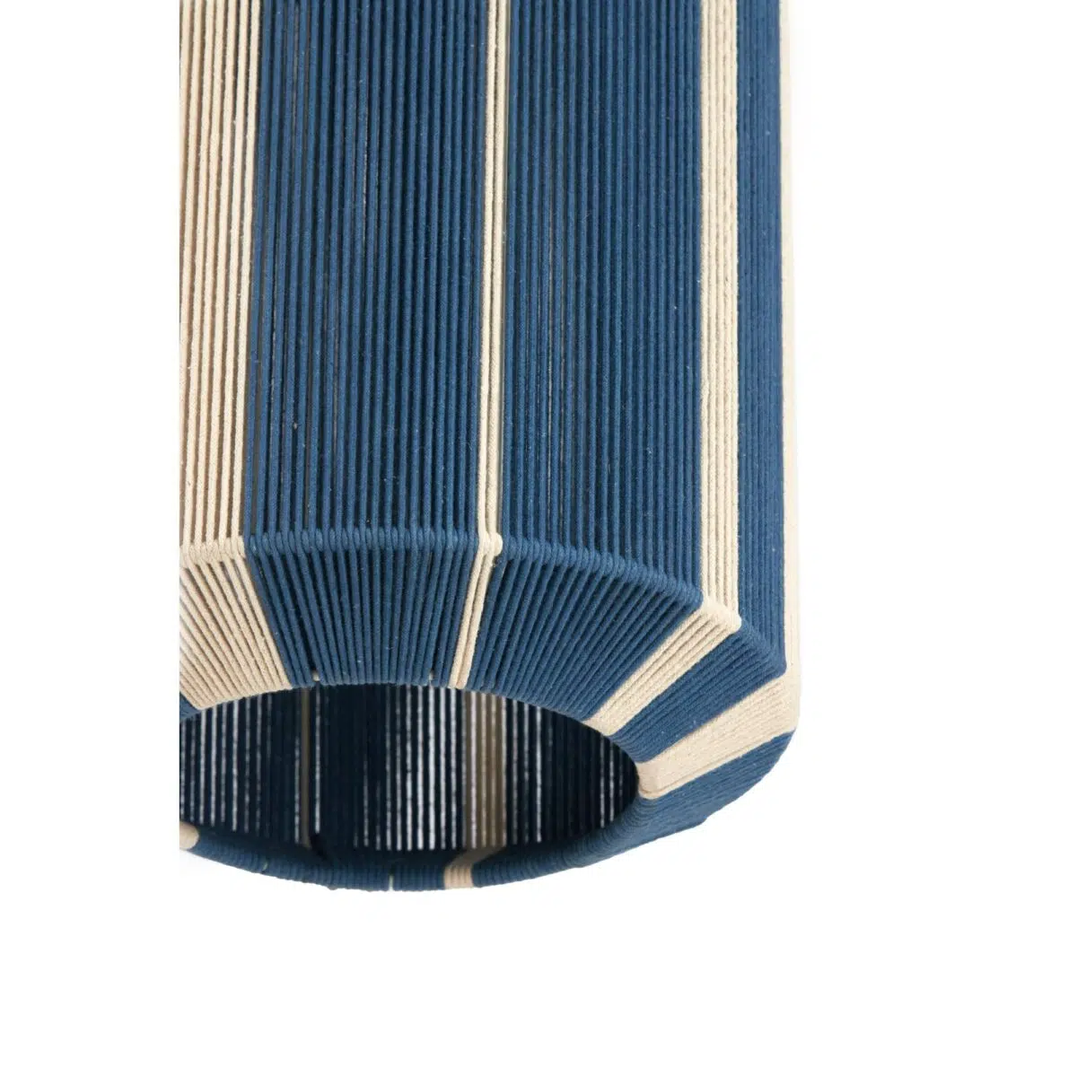 Een close-up van een cilindrische, geribbelde lampenkap met afwisselende blauwe en beige verticale strepen. De onderkant van de kap gaat open en toont het getextureerde oppervlak en het geometrische patroon.