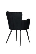 Een moderne zwarte fluwelen fauteuil met strakke, smalle metalen poten. De stoel heeft een gebogen rugleuning en armleuningen, wat een stijlvol en comfortabel design biedt. De bekleding heeft een gladde textuur.
