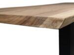 Close-up van een houten tafelhoek met een natuurlijke houtnerf. Het tafelblad is licht afgeschuind en rust op een zwarte metalen steun, wat een minimalistisch ontwerp laat zien. De focus ligt op de textuur en kleur van het hout.