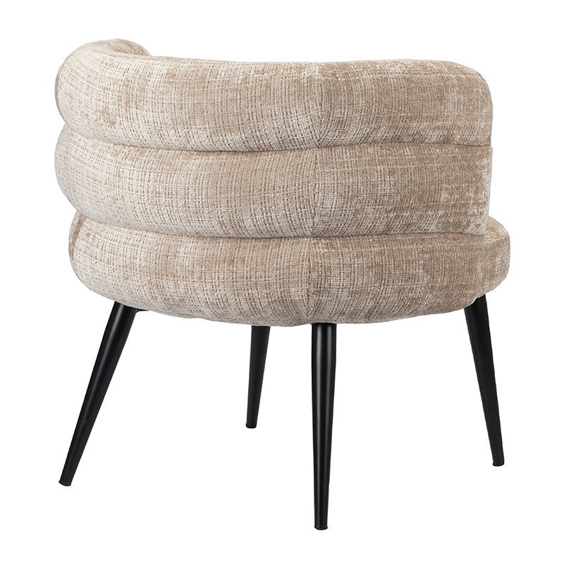 Een moderne beige fauteuil met een ronde, donzige rugleuning en zitting, ondersteund door vier strakke zwarte poten. De bekleding heeft een getextureerd, geweven patroon.