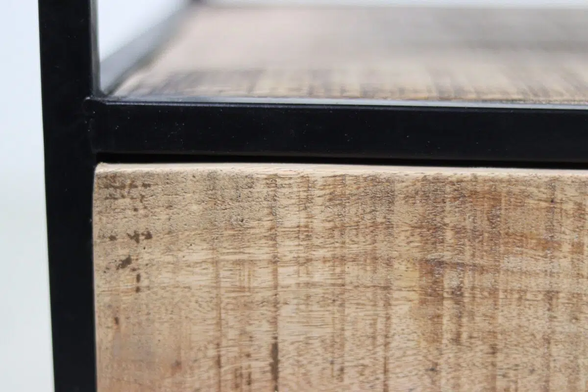 Close-up van een houten oppervlak omlijst door een zwarte metalen rand. Het hout heeft een getextureerde, natuurlijke nerf en een lichtbruine kleur, die contrasteert met het strakke, donkere metalen frame. De hoek toont een zijaanzicht, wat de nadruk legt op de materialen en structuur.