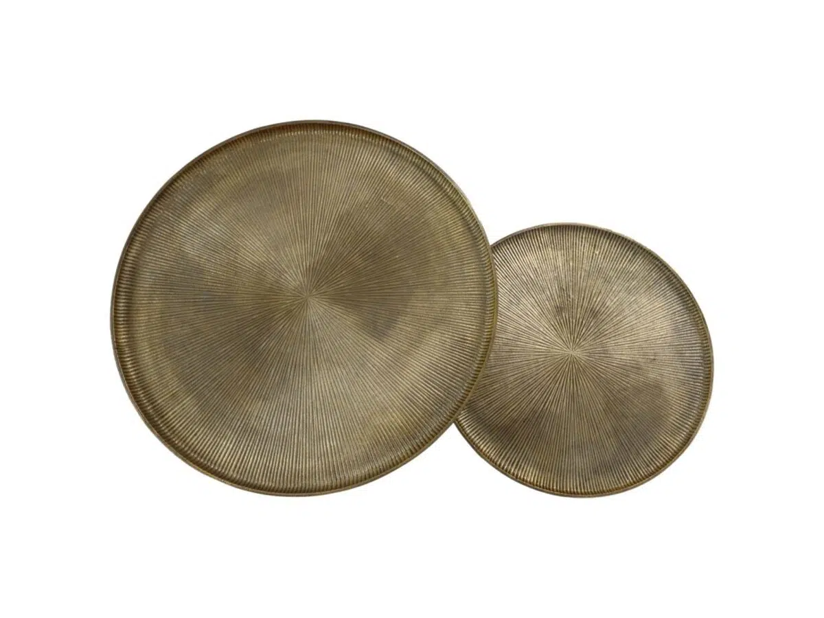 Twee ronde, getextureerde metalen dienbladen met een subtiel zonnestralenpatroon. Het grotere dienblad overlapt een deel van het kleinere, beide met een bronsachtige afwerking op een witte achtergrond.