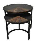 Twee ronde, geneste tafels met zwarte metalen frames en donkere houten bladen. De houten bladen hebben driehoekige inlegwerkjes, wat een geometrisch ontwerp toevoegt. De grotere tafel staat iets naar achteren, met de kleinere vooraan.