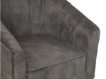 Donkergrijze fluwelen fauteuil met een zachte, gewatteerde zitting. De stoel heeft verticale stiksels langs de rugleuning en armen, wat het moderne ontwerp versterkt. De textuur oogt zacht en comfortabel.