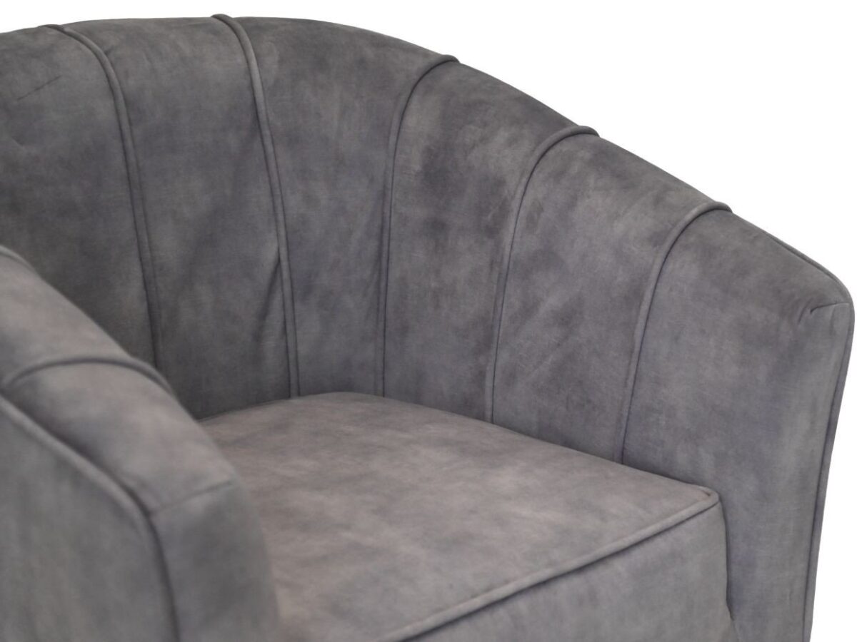 Close-up van een grijze gestoffeerde fauteuil met een gebogen rugleuning en verticale stiksels. De stof heeft een gladde textuur, waardoor de stoel een moderne en comfortabele uitstraling heeft.
