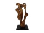 Een houten sculptuur met een abstract, vloeiend ontwerp, met kronkelende rondingen en natuurlijke houtnerfpatronen. Het staat op een eenvoudige zwarte basis, waardoor de vrije vorm en het getextureerde oppervlak worden benadrukt.