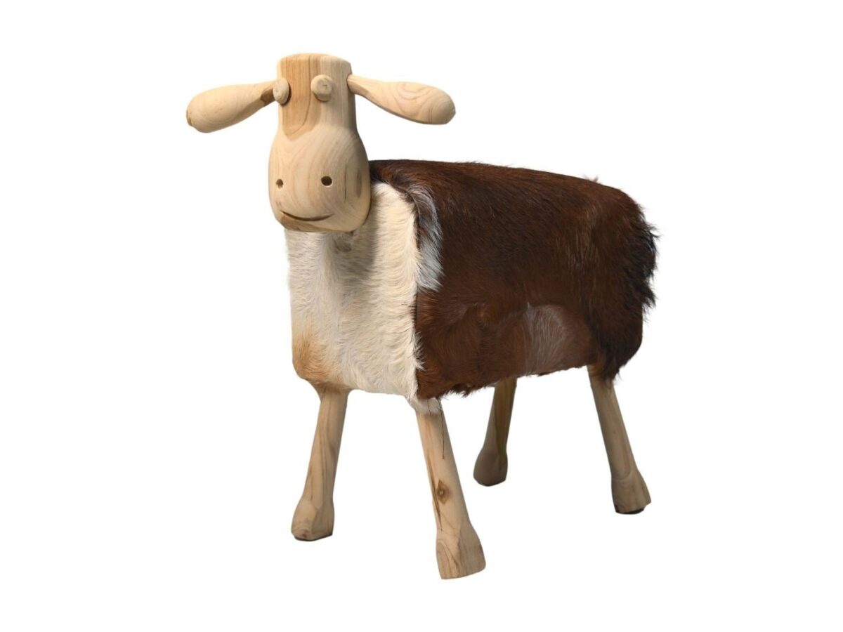 Een houten beeld van een schaap met eenvoudige gebeeldhouwde gelaatstrekken en een lichaam bedekt met bruin en wit bont, staand op vier stevige poten op een witte achtergrond.
