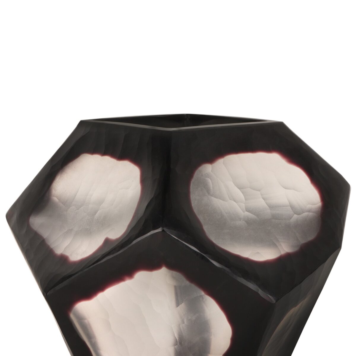 Een geometrisch, metalen, gefacetteerd object met zwarte en reflecterende zilveren oppervlakken, dat lijkt op een abstract beeldhouwwerk. Het oppervlak heeft drie prominente zilveren gebieden met onregelmatige vormen. De achtergrond is effen wit.