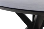 Close-up van de rand van een zwarte houten tafel en een deel van de strakke zwarte metalen poten, die een X-vorm vormen. De achtergrond is wit, wat het moderne ontwerp en de contrasterende texturen van de tafel benadrukt.