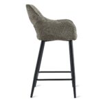 Zijaanzicht van een moderne barkruk met een getextureerde, grijs gestoffeerde zitting en een zwart metalen frame. Het ontwerp heeft een hoge rugleuning en voetensteun, wat een eigentijdse stijl combineert met comfort.