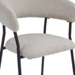 Een moderne stoel met een beige stoffen zitting en rugleuning met textuur. De stoel heeft strakke zwarte metalen poten en een open design. De bekleding oogt zacht en pluche, wat zorgt voor een comfortabele zitervaring.