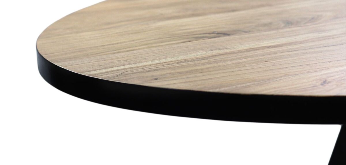 Close-up van een rond houten tafelblad met een gladde, lichte houtnerf afwerking, omrand met een dunne, donkere metalen strip. Het oppervlak is gekanteld, waardoor de textuur en het kleurcontrast tussen het hout en het metaal worden benadrukt.