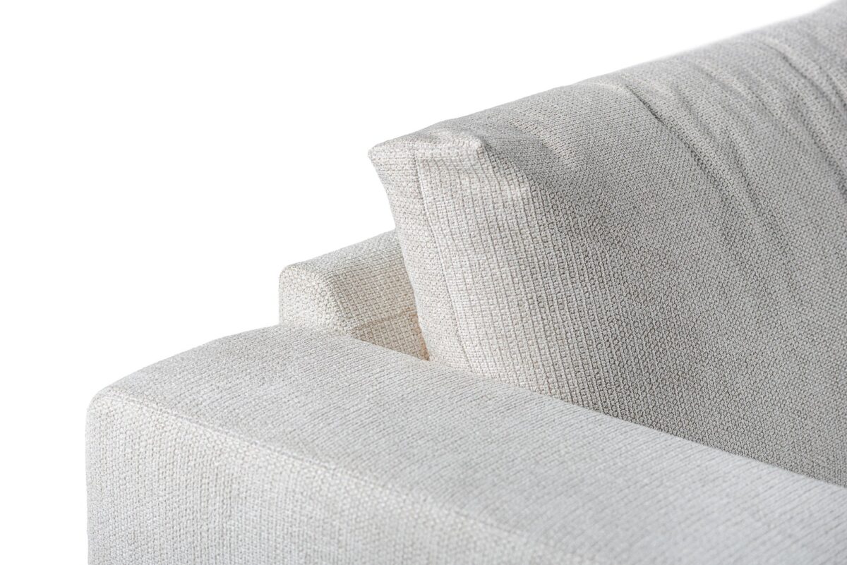 Close-up van de hoek van de 3 zits hoek rechts bank in de stof E460 beige Lord 22, met de gestructureerde bekleding en een deel van de rugleuning en armleuning tegen een witte achtergrond.