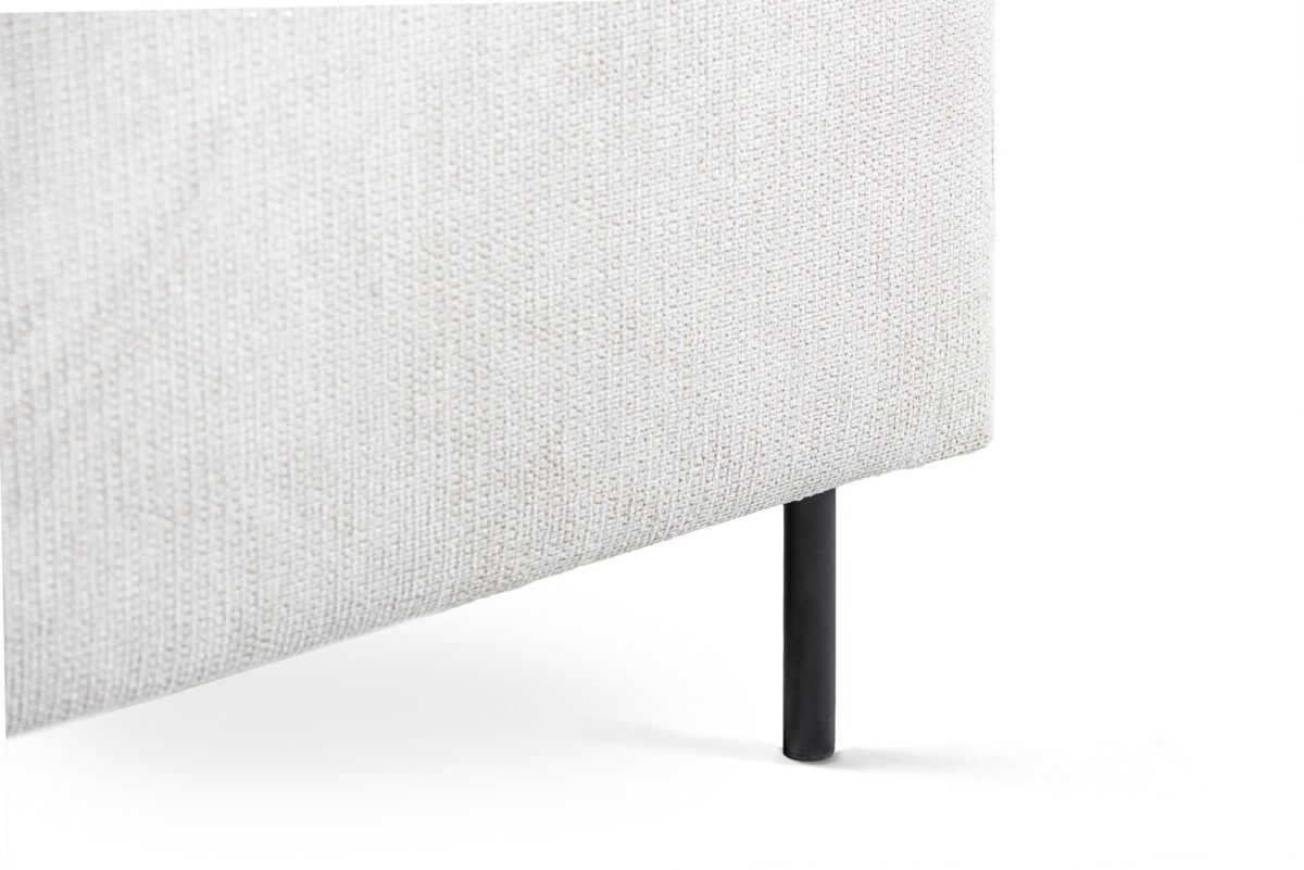 Close-up van de onderste hoek van de 3 zits hoek links, stof Lord 22, E460 beige, met de gestructureerde lichtbeige bekleding en dunne zwarte metalen poot tegen een witte achtergrond.