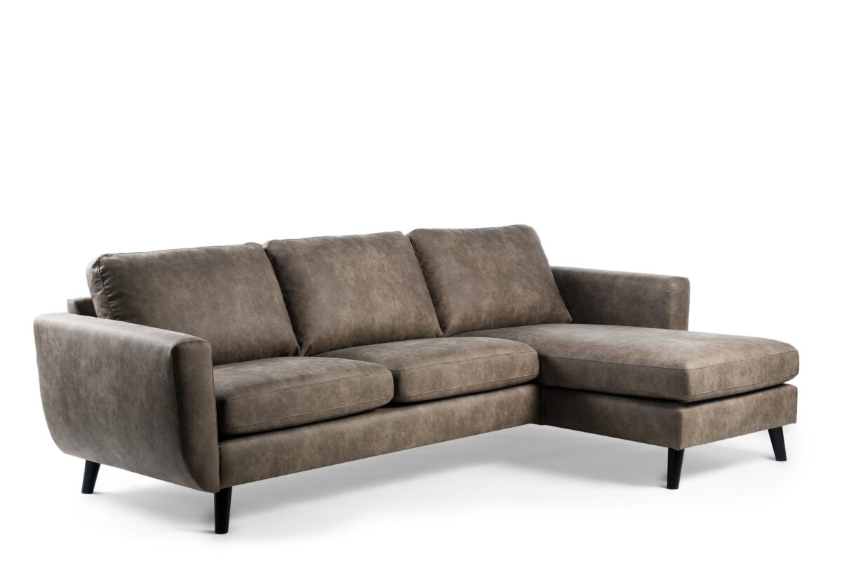 De 3 zits bank CL L+R, bekleed met Savannah S520 taupe stof en voorzien van drie zitkussens, een chaise lounge rechts en zwarte tapse poten, schittert voor een witte achtergrond.